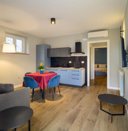 a kitchen and living room with a red table and chairs at B&B Dimora Morelli in Gubbio