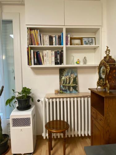 une chambre avec un radiateur, une table et des livres dans l'établissement AUBER Modern big apartment with Parking 12 minutes from Metro, à Vitry-sur-Seine