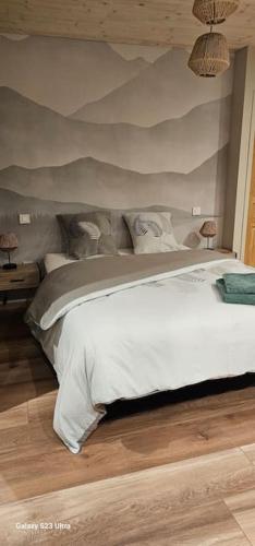 - une chambre avec un grand lit blanc et un mur dans l'établissement Studio Au coeur du Val Meublé de tourisme 4 étoiles, à Le Valdahon