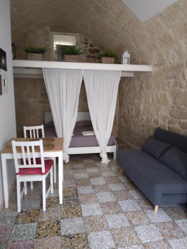 a living room with a table and a couch at Piazzetta Scolanova in Trani