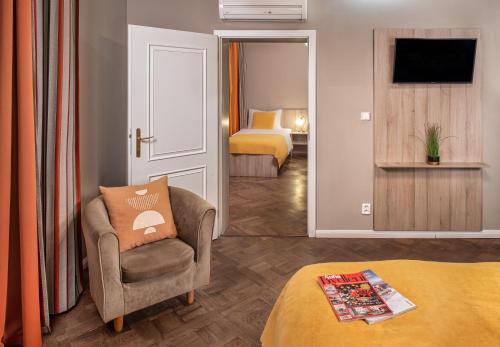 a living room with a chair and a bedroom at Hotel "Palác U Kočků" by Adrez, Palace At the Cats in Prague