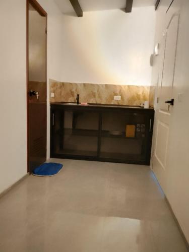 una habitación vacía con cocina y puerta en Shawe pension house, en San Remigio
