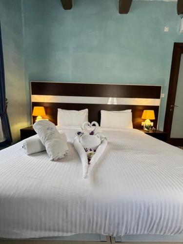 a white bed with two towels in the shape of a heart at My Travel House in Rabat