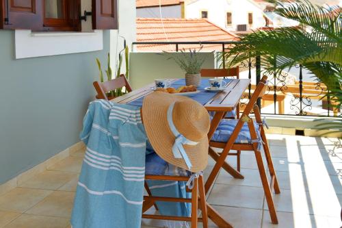 a table with a straw hat sitting on a balcony at Captain Ilias House Chalki in Halki