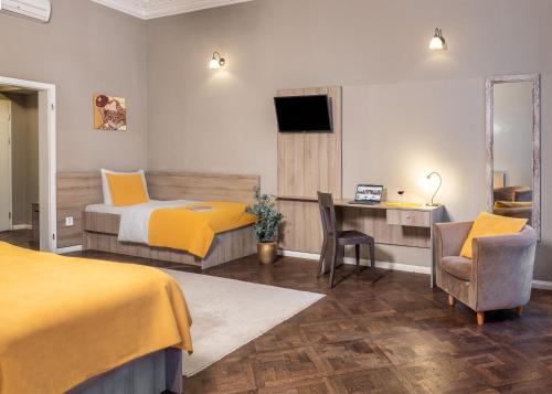 a hotel room with two beds and a desk and a television at Hotel "Palác U Kočků" by Adrez, Palace At the Cats in Prague