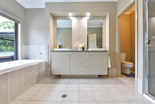 La salle de bains est pourvue d'une baignoire, d'un lavabo et de toilettes. dans l'établissement The Residence - Ironstone Estate Hunter Valley, à Lovedale