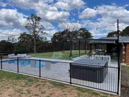 une piscine entourée d'une clôture dans l'établissement The Residence - Ironstone Estate Hunter Valley, à Lovedale