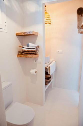 a white bathroom with a toilet and some towels at Can Roca - Modern & Stylish Villa in San Ferrán de ses Roques