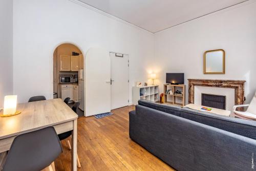 un salon avec un canapé et une cheminée dans l'établissement Appartement Secteur Cathédrale - Hypercentre - Albi, à Albi
