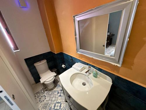 a bathroom with a sink and a toilet and a mirror at My Travel House in Rabat