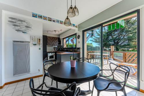 une cuisine et une salle à manger avec une table et des chaises dans l'établissement Maison Ostrea bassin d'arcachon, à Gujan-Mestras