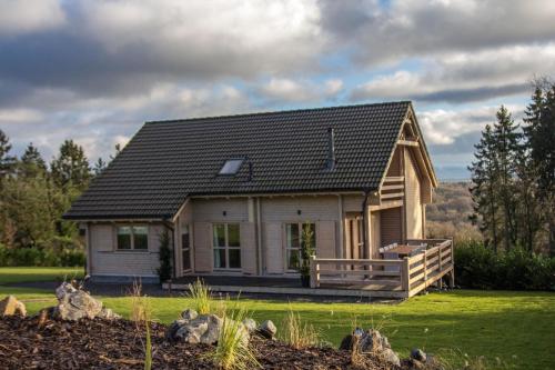 una pequeña casa con techo de gambrel en Ferienhaus für 9 Personen und 1 Kind in Durbuy, Wallonie Provinz Luxeburg, en Durbuy