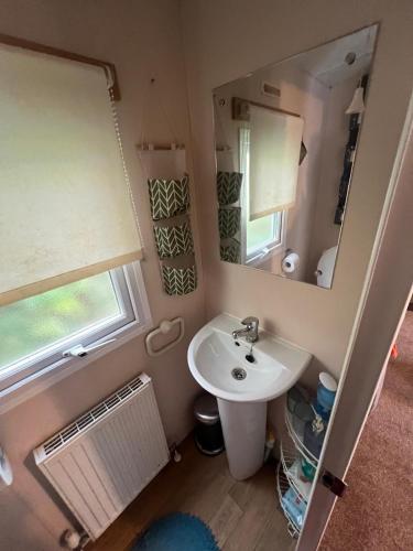 a small bathroom with a sink and a mirror at HOLIDAY PARK HOUSE in Hastings