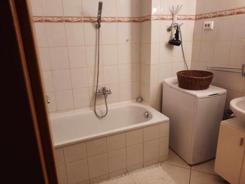 ein Badezimmer mit einer Badewanne, einem WC und einem Waschbecken in der Unterkunft Boróka 3 Apartman in Hajdúszoboszló