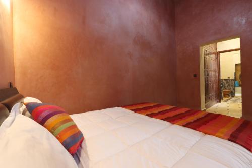 a bedroom with a bed with a colorful blanket at Riad Dwiriyat My Teib in Marrakech