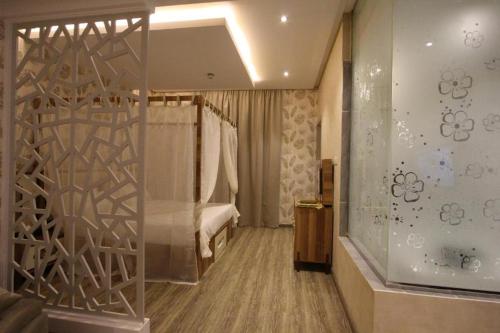Habitación de hotel con cama y pared de cristal en حياة روز للشقق الفندقية, en Riad