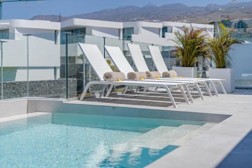 una mesa blanca y sillas junto a una piscina en Villa Estándar 1 - Casangular by Upper, en Adeje