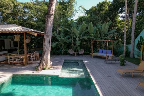 a swimming pool with a table and chairs on a deck at Villa Mediterrâneo Trancoso in Trancoso