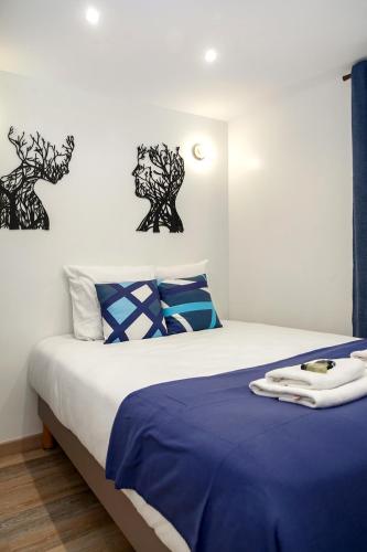 une chambre avec un lit avec des draps bleus et blancs dans l'établissement Nets Inn apartments - Robida, à Paris