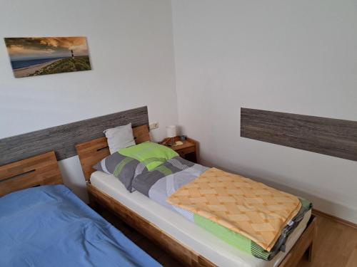 a bedroom with two beds and a picture on the wall at Ferienwohnung Hilgert in Sankt Sebastian