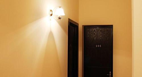 una stanza con una porta nera e una luce sul muro di VIP apart 541 a Tbilisi City