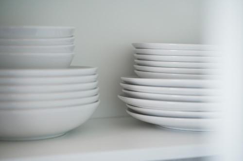 two stacks of white bowls sitting on a shelf at Monteurwohnungen in Göppingen 04-07 in Göppingen