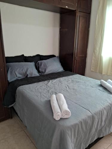 a bed with two towels on top of it at Casa espaçosa em Belo Horizonte in Belo Horizonte