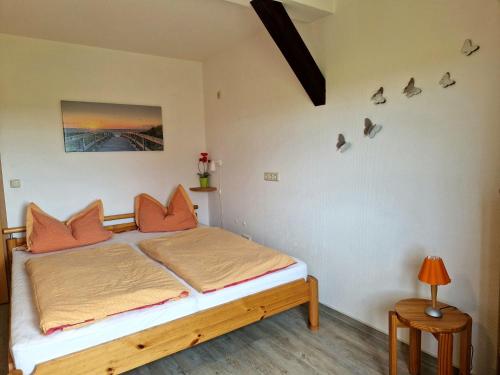 ein Schlafzimmer mit einem Bett mit orangefarbenen Kissen darauf in der Unterkunft Insel-Idyll Sonnenschein in Insel Poel