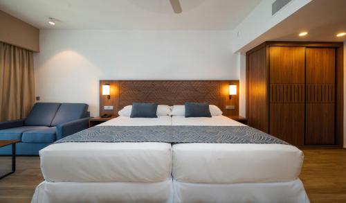 a bedroom with a large bed and a blue chair at Riu Montego Bay - Adults Only - All Inclusive in Montego Bay