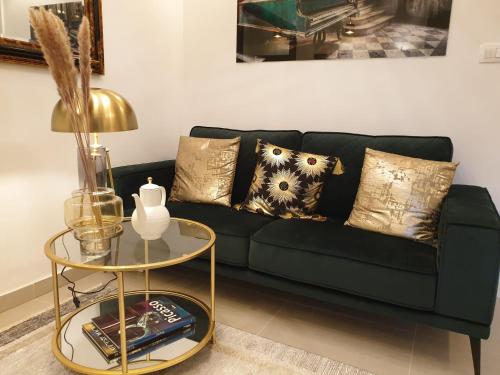 a green couch with pillows and a table in a living room at Split Old Town Oasis in Split