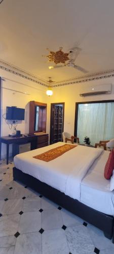 a large bedroom with two beds and a desk at Hotel Darbargarh A Unit of Khamma Ghani A Boutique Hotel in Udaipur