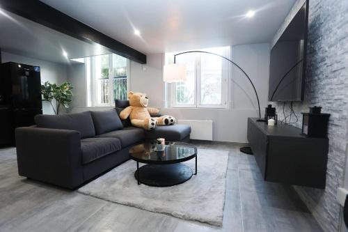 ein Wohnzimmer mit einem Teddybär auf einer Couch in der Unterkunft CasaLova in Épinay-sur-Seine