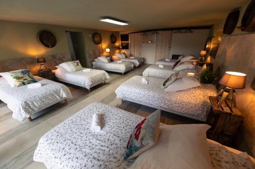 a living room with four beds and a couch at Mas Loisonville - Demeure d'exception & Spa en Drôme Provençale in Grillon