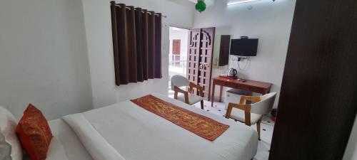 a bedroom with a bed and a desk and a table at Hotel Darbargarh A Unit of Khamma Ghani A Boutique Hotel in Udaipur