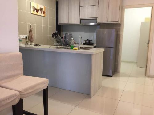 a kitchen with a counter and a refrigerator at Icon Residenz Icon City, Petaling Jaya by De Harlequins Guesthouse in Petaling Jaya