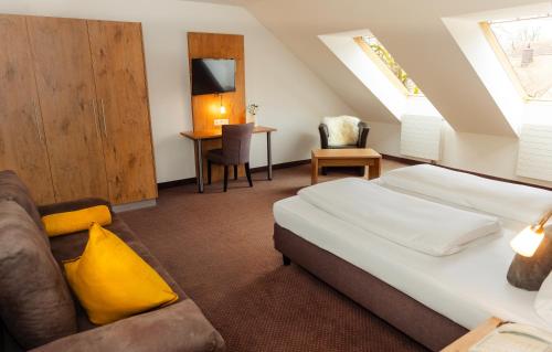 a hotel room with a bed and a couch at Hotel am Hachinger Bach by Blattl in Neubiberg