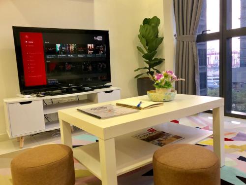 a living room with a tv and a table and chairs at Icon Residenz Icon City, Petaling Jaya by De Harlequins Guesthouse in Petaling Jaya