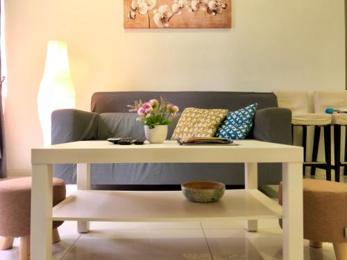 a white coffee table in front of a couch at Icon Residenz Icon City, Petaling Jaya by De Harlequins Guesthouse in Petaling Jaya