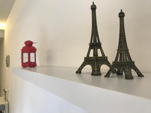 two miniature eiffel towers on a shelf with a red lantern at Icon Residenz Icon City, Petaling Jaya by De Harlequins Guesthouse in Petaling Jaya