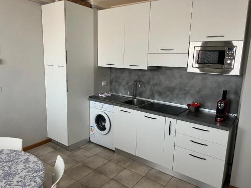 a kitchen with a sink and a washing machine at Hotel Lydia in Grado