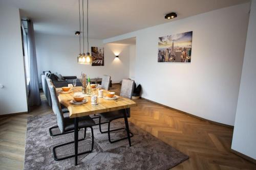 杜伊斯堡的住宿－Stilvolle Stadtwohnung，一间带木桌和椅子的用餐室
