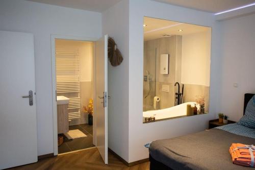 a bedroom with a bed and a bathroom with a mirror at Stilvolle Stadtwohnung in Duisburg