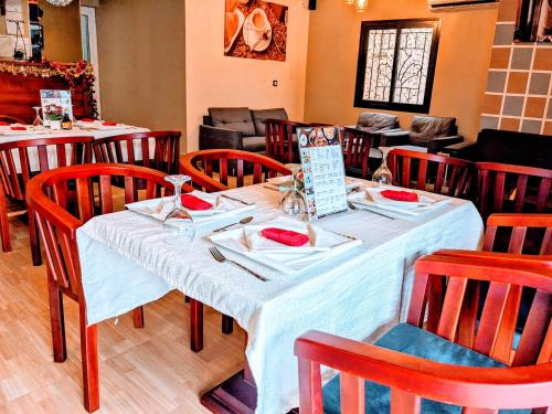 uma sala de jantar com uma mesa com cadeiras vermelhas em ALICIA HOTEL em Douala