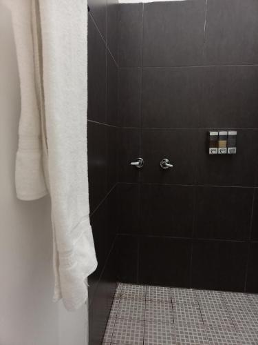 a bathroom with a shower with a white shower curtain at DGM Lofts MTY MN 960 F centro cerca de todo in Monterrey