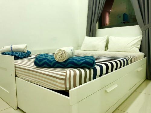 two twin beds in a room with a mirror at Icon Residenz Icon City, Petaling Jaya by De Harlequins Guesthouse in Petaling Jaya