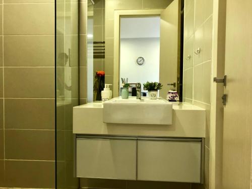 a bathroom with a white sink and a mirror at Icon Residenz Icon City, Petaling Jaya by De Harlequins Guesthouse in Petaling Jaya