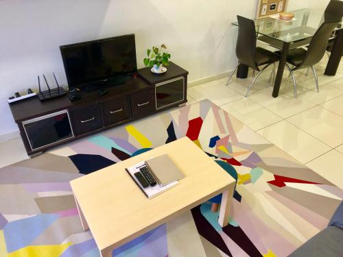 a living room with a table with a laptop on it at Icon Residenz Icon City, Petaling Jaya by De Harlequins Guesthouse in Petaling Jaya