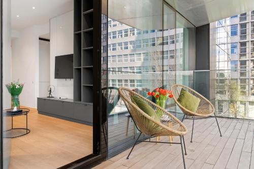 um quarto com duas cadeiras e uma mesa com uma televisão em ONE Luxury Apartments em Bucareste