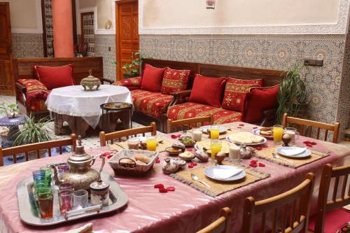 a table with a pink table cloth and a couch at Riad Dwiriyat My Teib in Marrakech