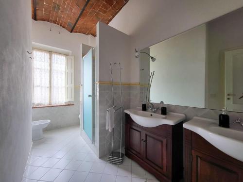 un ampio bagno con due lavandini e una doccia di Le Antiche Scale 9 a Lucca